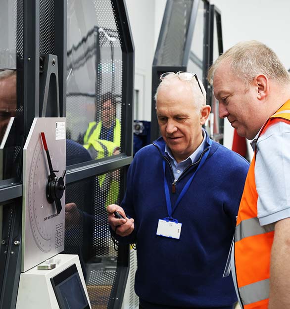 A customer visiting our UKAS Laboratory, operating one of our Charpy impact testers.